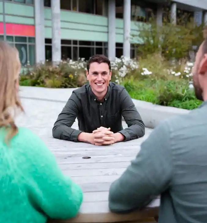 Zelfverzekerde young professional aan picknicktafel met collega's van Stevin