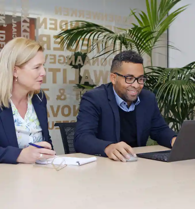 Twee Collega's Vindsubsidies achter laptop op kantoor